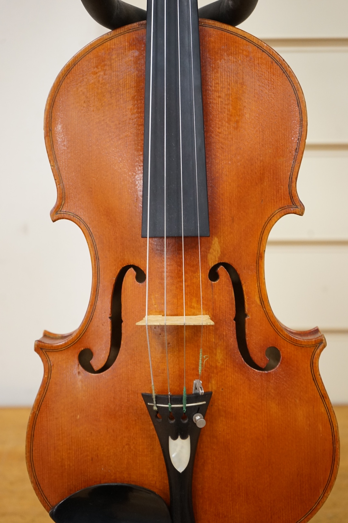 Three violins; a late 19th century German Stradivarius pattern violin, without label, a handmade violin (a.f.), with sound post crack, broken and repaired scroll, etc. and a Maidstone violin body, varnish stripped from t